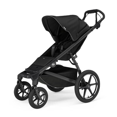All-terrain Thule Urban Glide 4-Wheel stroller in black, featuring a large canopy, adjustable seat, and storage basket.