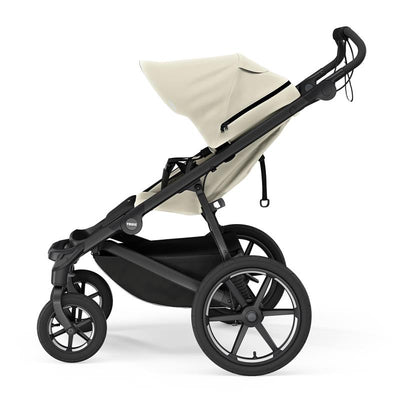 Single-child Thule Urban Glide all-terrain stroller in soft beige, featuring a large canopy and four sturdy wheels.