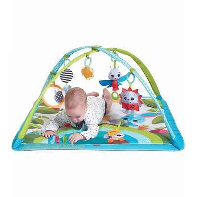 Baby playing on the Tiny Love Meadow Day Sunny Day Gymini activity mat with hanging toys and colorful patterns.