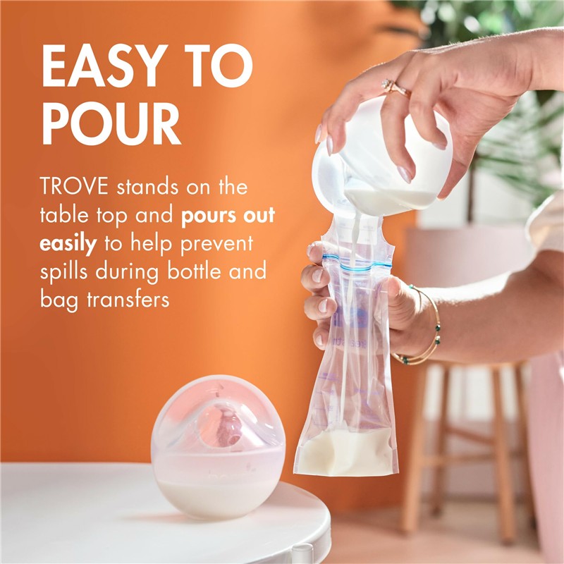 Boon TROVE silicone breast milk collection cup being poured into a storage bag, demonstrating spill prevention features.