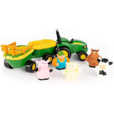 Toy John Deere tractor with green trailers, farmer figure, and colorful plastic farm animals including a pig, sheep, and cow.