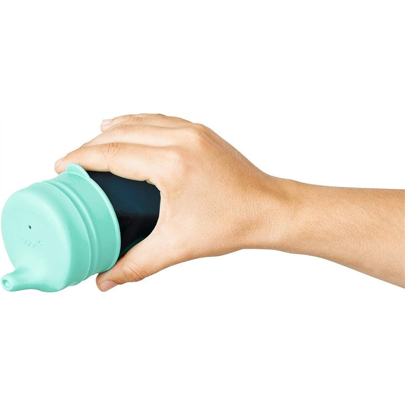 Hand holding a teal Boon SNUG Spout Sippy Cup, showcasing its spout and sleek design.