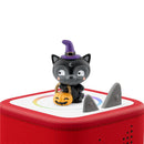 Black cat figurine with a purple witch hat and a pumpkin candy bucket atop a red audio toy, designed for Halloween songs.