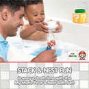 A smiling child holds a Mario figure in a bath, splashing water, with an adult nearby and colorful bath toys.