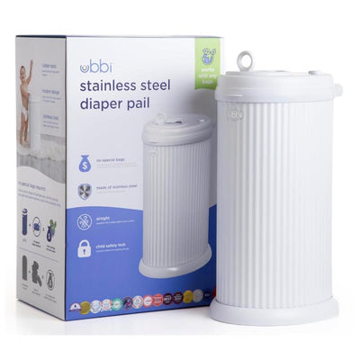Ubbi fluted stainless steel diaper pail in white next to its packaging, featuring airtight design and child safety lock.