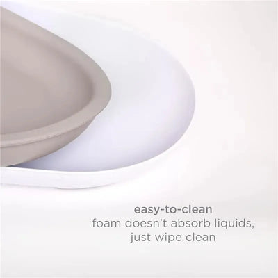 Taupe foam changing pad on a white background, featuring text about easy cleaning and liquid resistance.