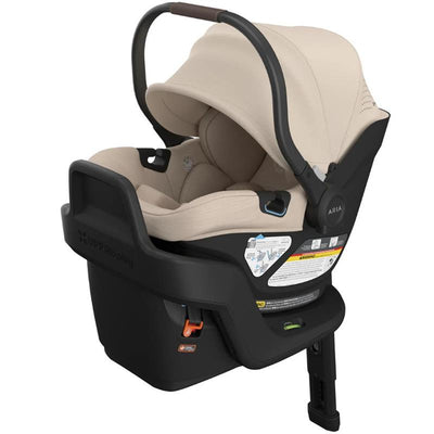 Lightweight Uppababy Aria V2 infant car seat in Declan (Oat Melange), featuring a beige seat and safety information labels.