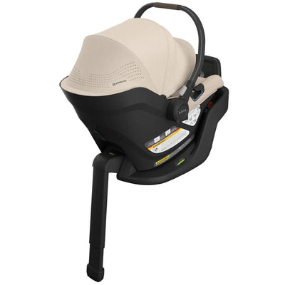 Lightweight Uppababy Aria V2 infant car seat in Declan (Oat Melange) color, featuring safety labels and a supportive handle.