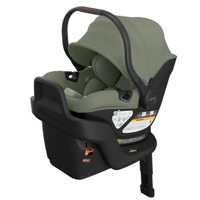 Lightweight Uppababy Aria V2 infant car seat in Meadow Green with a protective canopy and safety label visible.