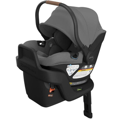 Lightweight Uppababy Aria V2 infant car seat in charcoal melange, featuring a safety harness, removable canopy, and instructional label.