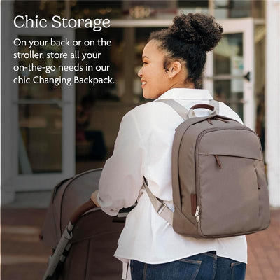 Changing Backpack by Uppababy in Stone Blue with Sand Leather, worn by a woman near a stroller, featuring chic storage design.