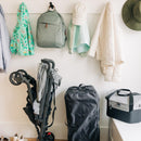 UPPAbaby G-Series Stroller Travel Bag and a folded stroller beside various jackets, a backpack, and a cooler.