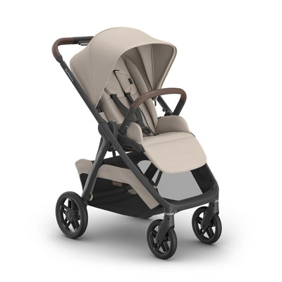 Uppababy Kona Stroller in Sandstone Mélange with a carbon frame and chestnut leather accents, featuring a reclining seat and canopy.