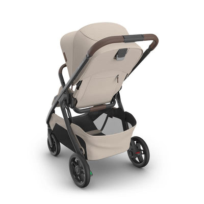Uppababy Kona Stroller in Sandstone Mélange, featuring a carbon frame and chestnut leather accents, viewed from the back.