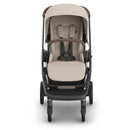 Uppababy Kona Stroller in Sandstone Mélange, featuring a cushioned seat, harness, and adjustable canopy, designed for child comfort.