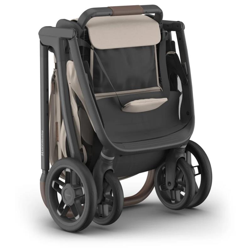 Uppababy Kona stroller in Sandstone Mélange, featuring a compact folded design with a dark frame and light fabric accents.