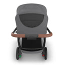 Uppababy Kona stroller with a grey canopy and brown handlebar, showcasing its rear view and spacious seating area.