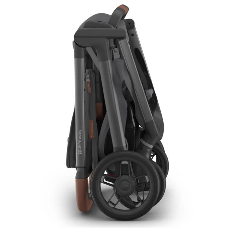 Uppababy Kona Stroller folded flat, showcasing its graphite color, with brown leatherette handle and details.