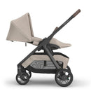 Uppababy Kona stroller in Ada (Sandstone Mélange) configuration with a tan seat and a black frame.