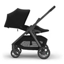 Uppababy Kona stroller in black, featuring a large canopy, comfortable seat, and spacious storage basket.