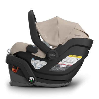 Uppababy Mesa V3 Infant Car Seat in Declan (Oat Mélange), featuring a beige canopy and multiple safety labels.
