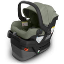 Uppababy Mesa V3 infant car seat in Meadow Green, featuring a secure harness, adjustable canopy, and safety labels.