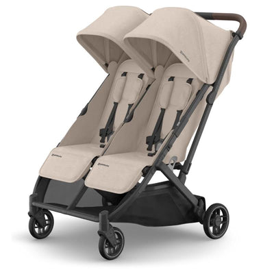 Uppababy Minu Duo stroller in Sandstone Melange with chestnut leather accents, featuring two seats and adjustable canopies.