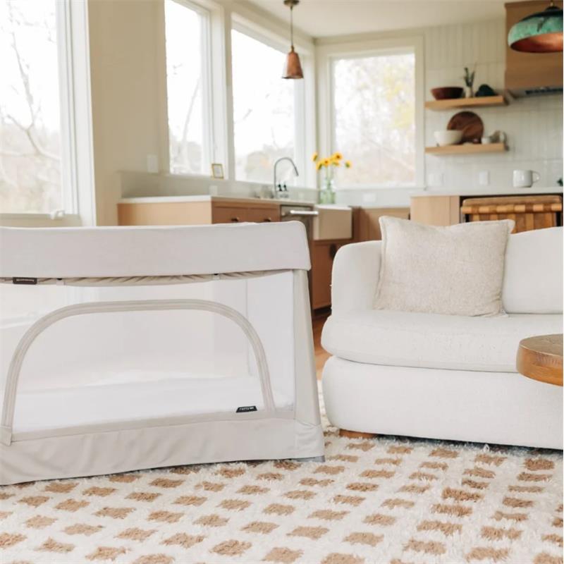 UPPAbaby Remi V2 Playard in Townsend Beige, featuring a soft knit fabric, positioned in a cozy living room setting.