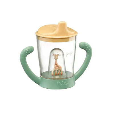 Non-spill slip cup featuring a transparent body, green handles, and a giraffe figurine inside with a yellow cap.
