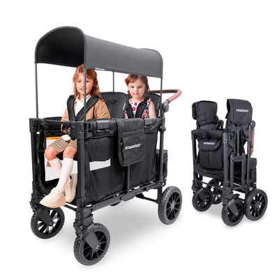 Jet Black Wonderfold W2 Luxe Pro Stroller Wagon with two children seated inside, featuring a canopy and storage pockets.
