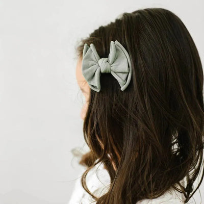 Baby Bling Bows grey ribbed fabric hair clip on a child's brown hair